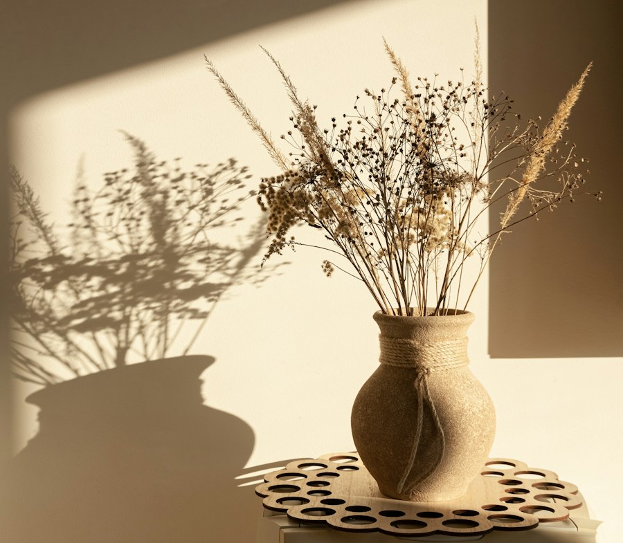 Dried grasses in a clay vase, in afternoon light