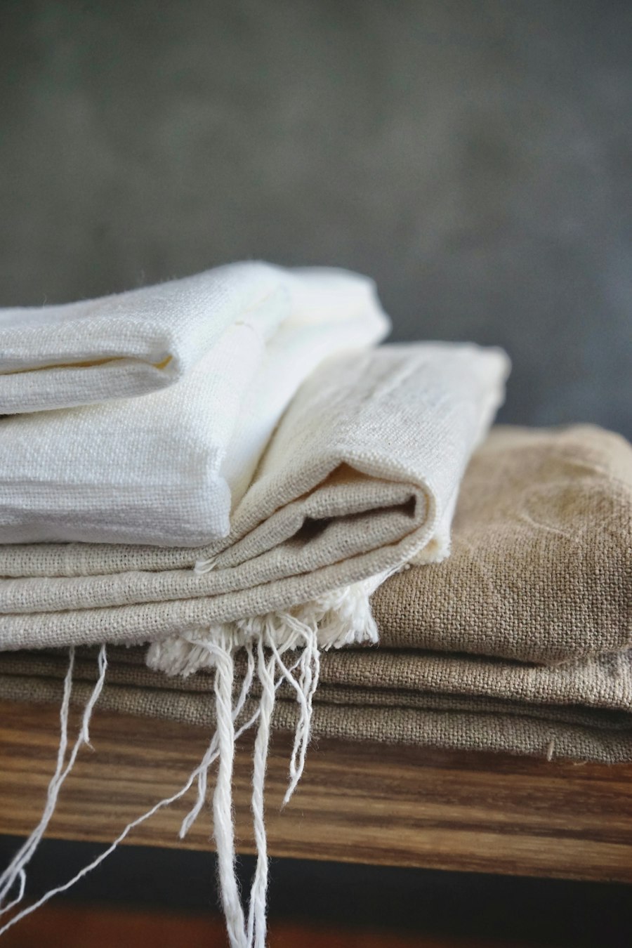 Folded linen textiles on a timber bench